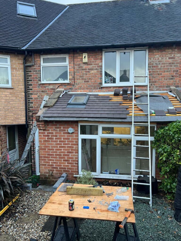 This is a photo of a roof extension that is having new roof tiles installed. This is a photo taken from the roof ridge looking down a tiled pitched roof on to a flat roof. Works carried out by Ollerton Roofing Repairs