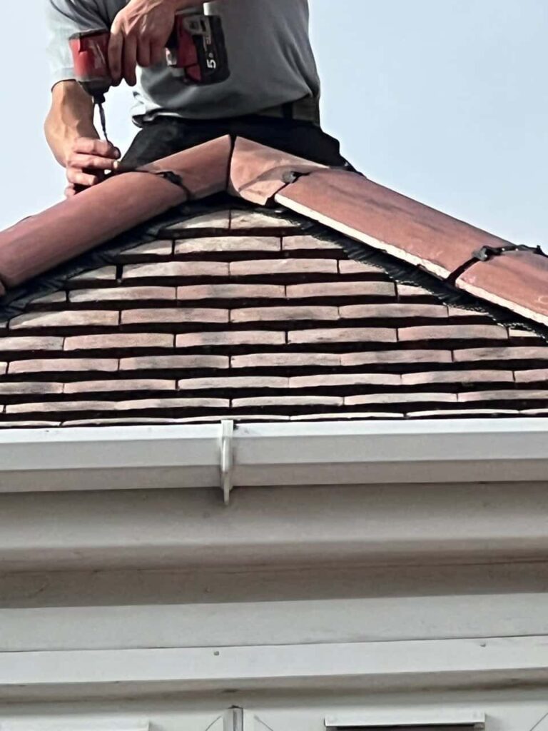 This is a photo of one of the operatives of Ollerton Roofing Repairs installing new ridge tiles